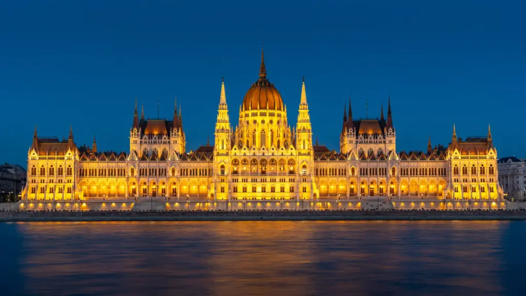 Illuminated parliament building on the Danube at dusk