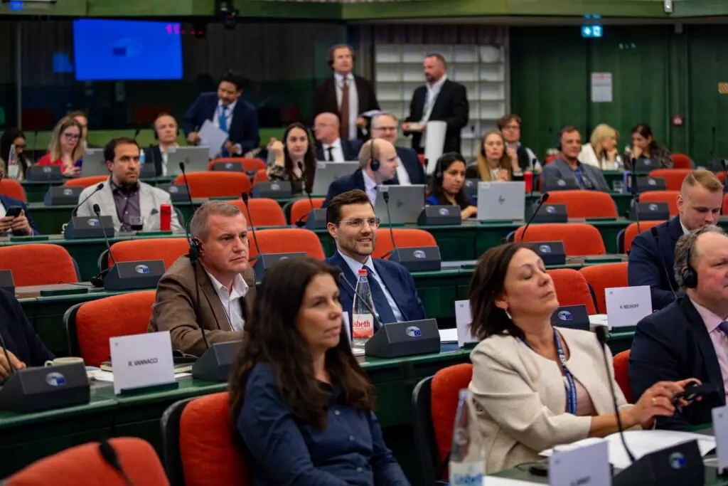 Members seated at their desks in the European Parliament plenary chamber in Strasbourg, wearing interpretation headsets during a debate