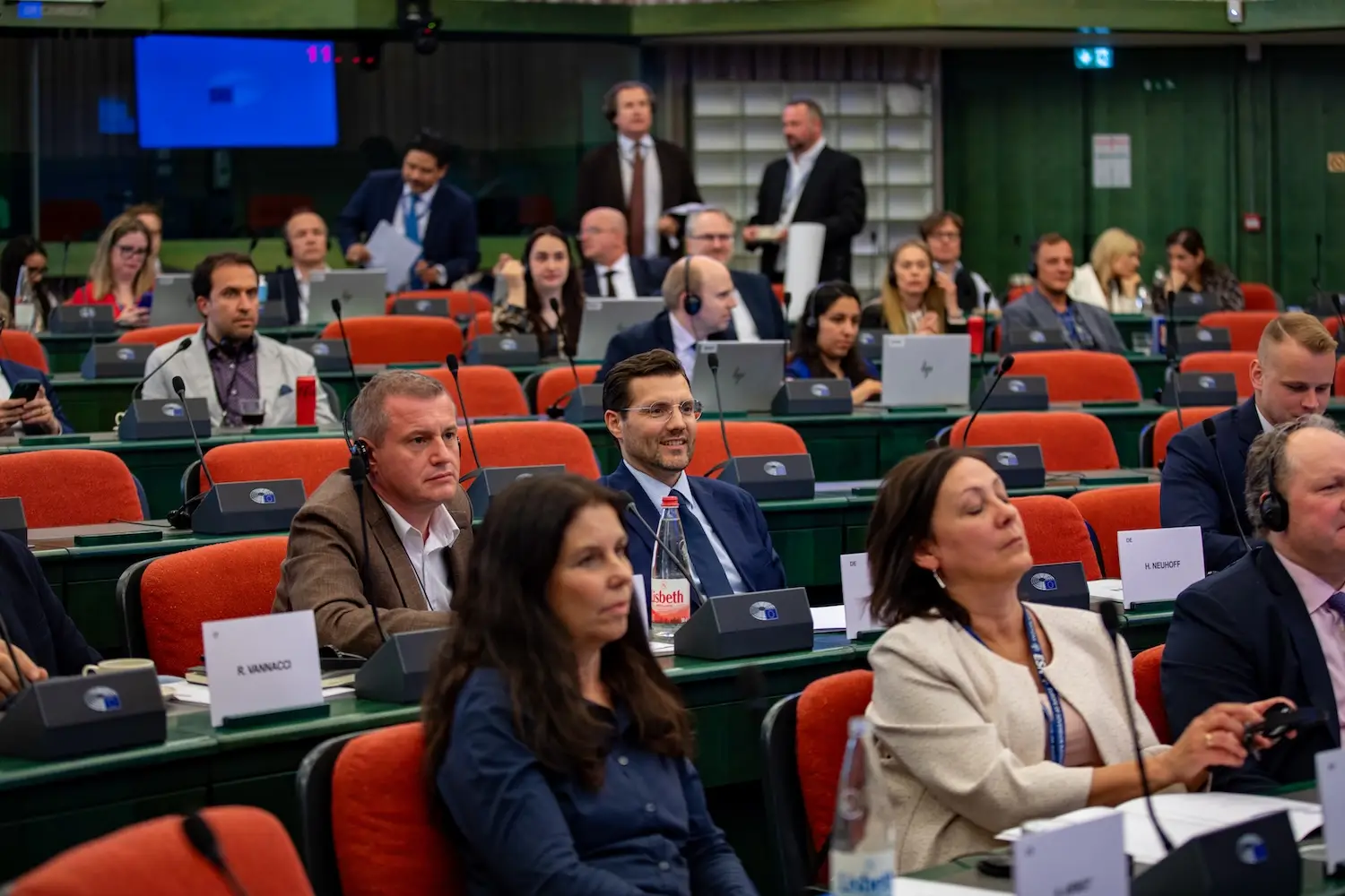 Members seated at their desks in the European Parliament plenary chamber in Strasbourg, wearing interpretation headsets during a debate