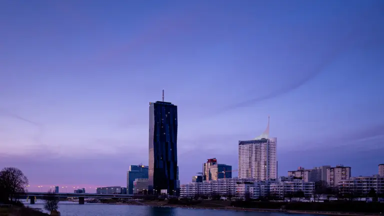 European financial district skyline at dusk, office towers beside a river